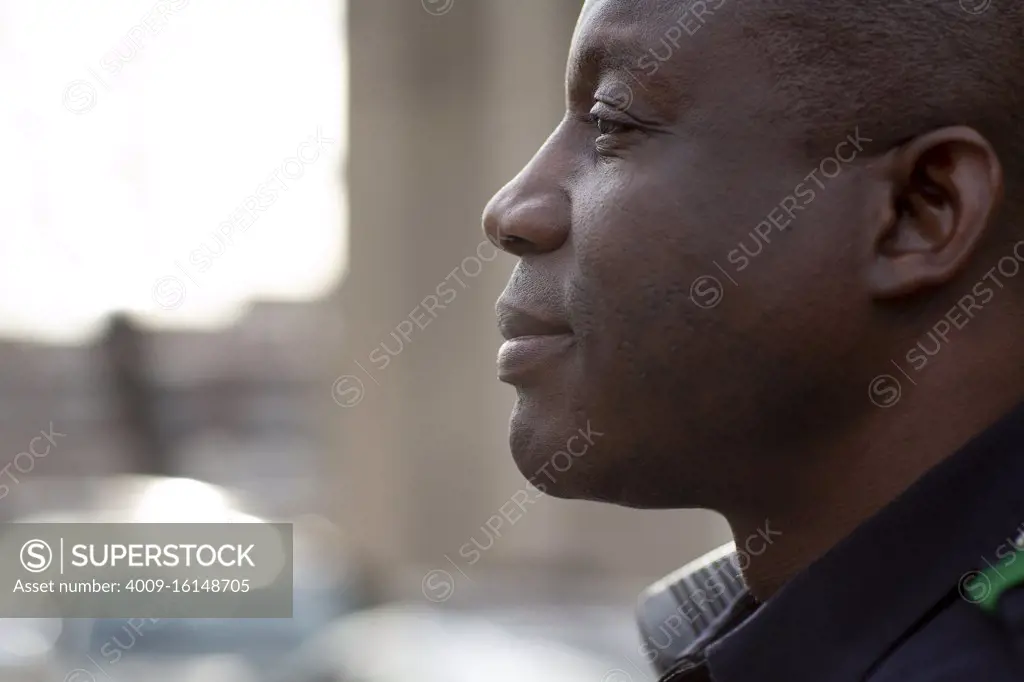 Close up profile Portrait of uniformed Police officer sitting outside looking off camera 