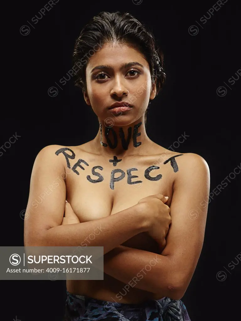 Portrait of Indian woman with arms crossed and words painted across neck and chest "Love + Respect"