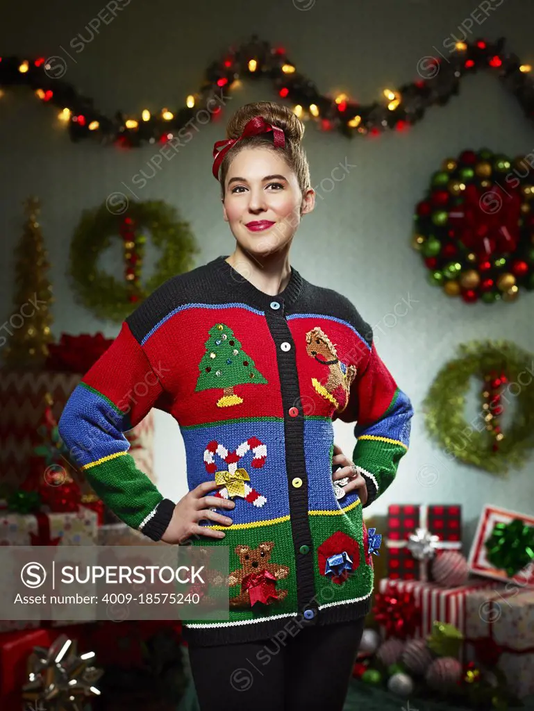 Portrait of woman in ugly Christmas sweater looking into camera with pride