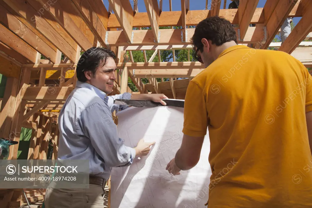 Contractor going over plans with a man at a residential construction site