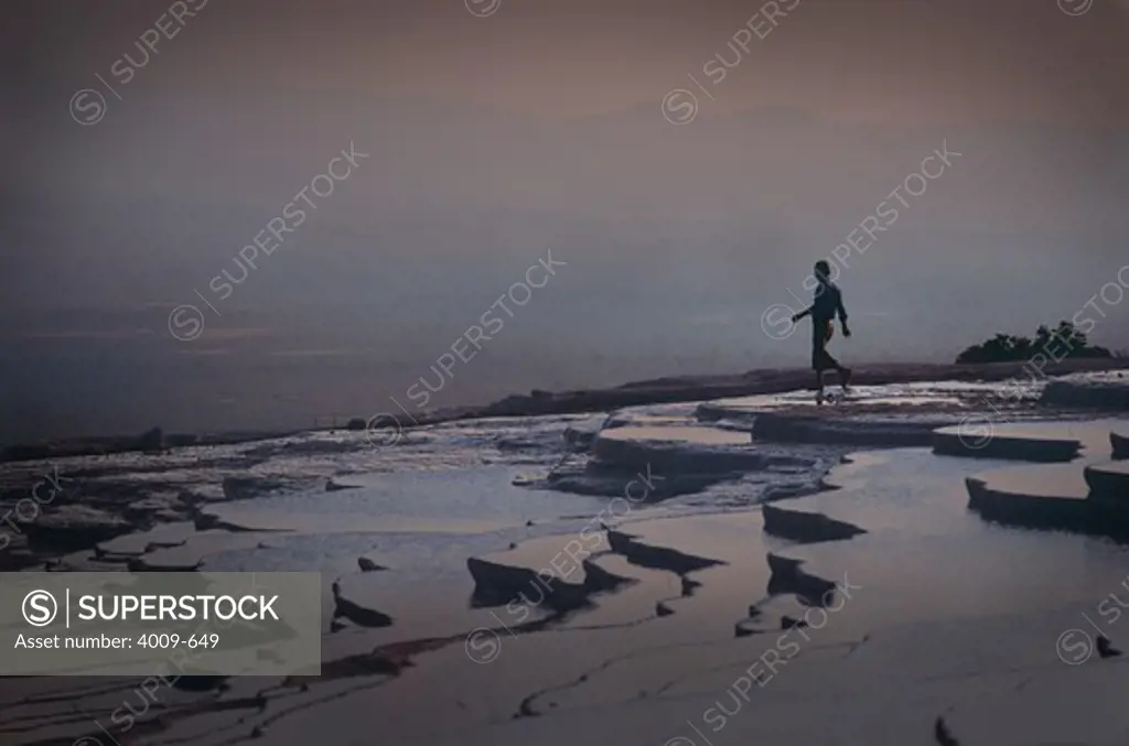 Person walking in travertine pools, Pamukkale, Turkey
