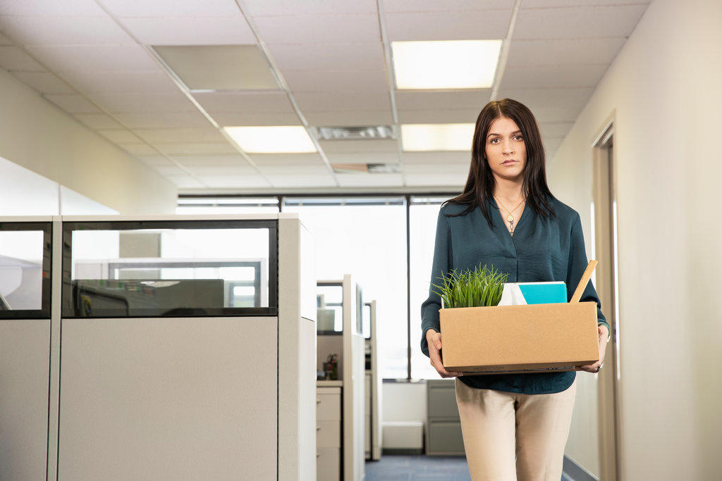 A young female employee carrying office possessions after being laid off. 