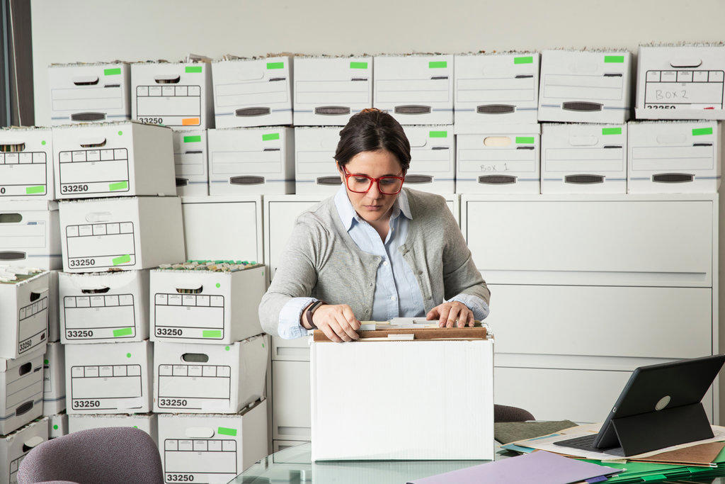 Young employee sorts through files in her office
