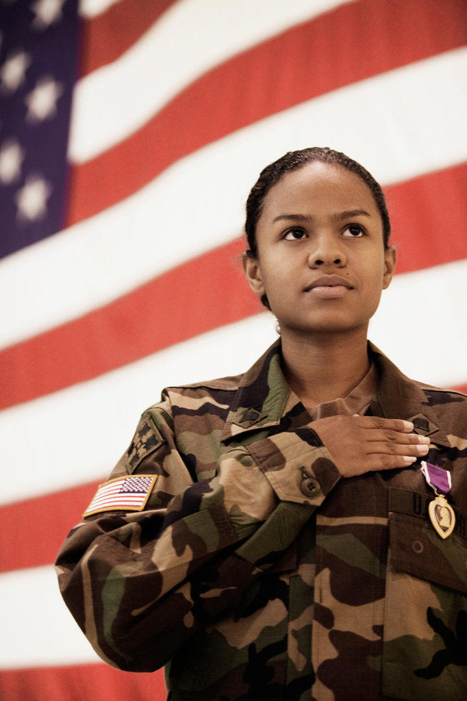 Hispanic female soldier in front of American flag