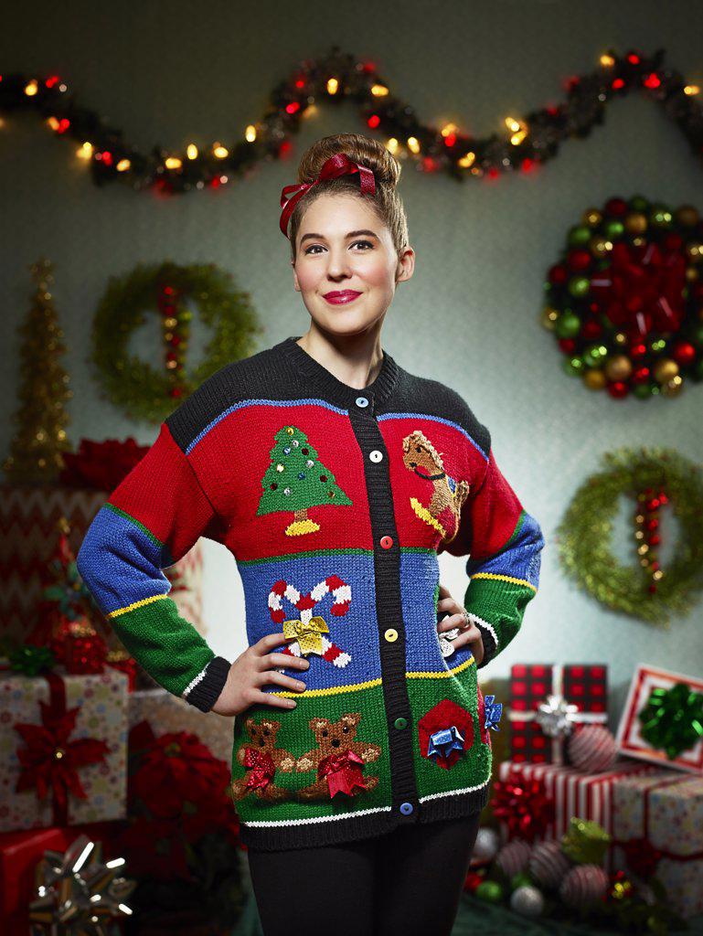 Portrait of woman in ugly Christmas sweater looking into camera with pride