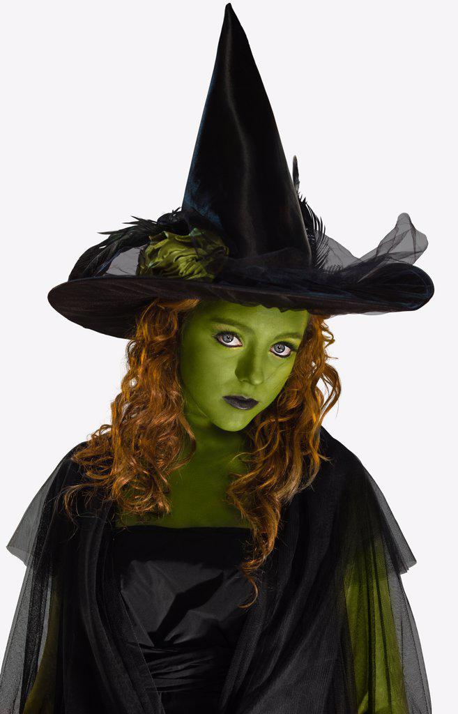 Portrait of a woman dressed as a witch with green body paint, looking into camera with attitude