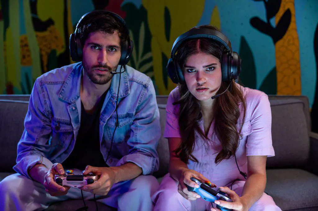 Young millennial couple playing video game at home