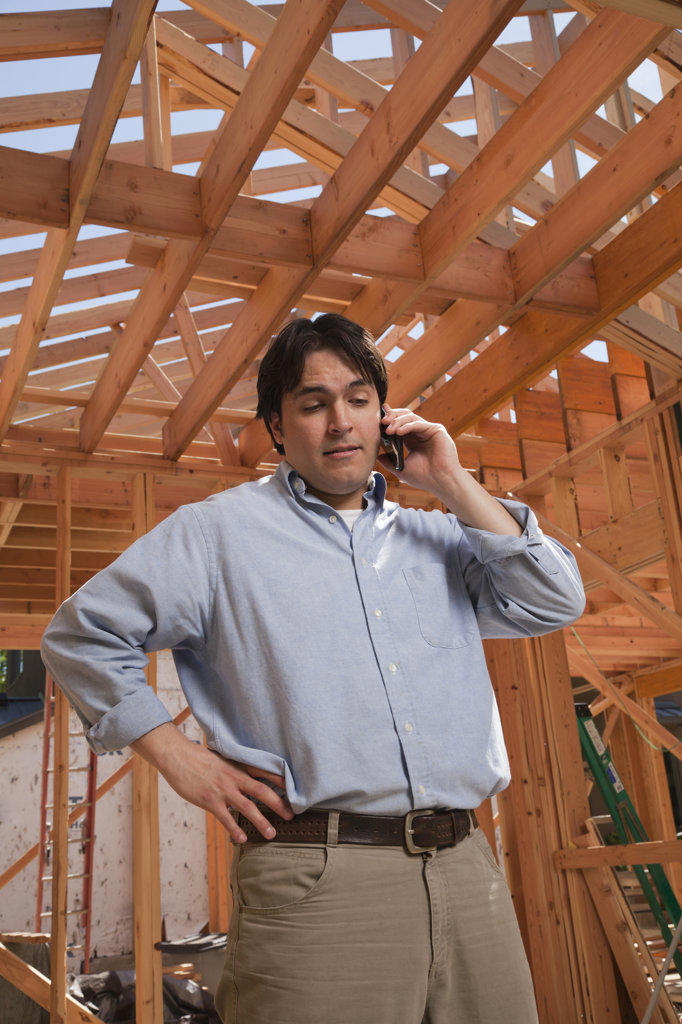 Man talking on his cellular phone at a residential construction site