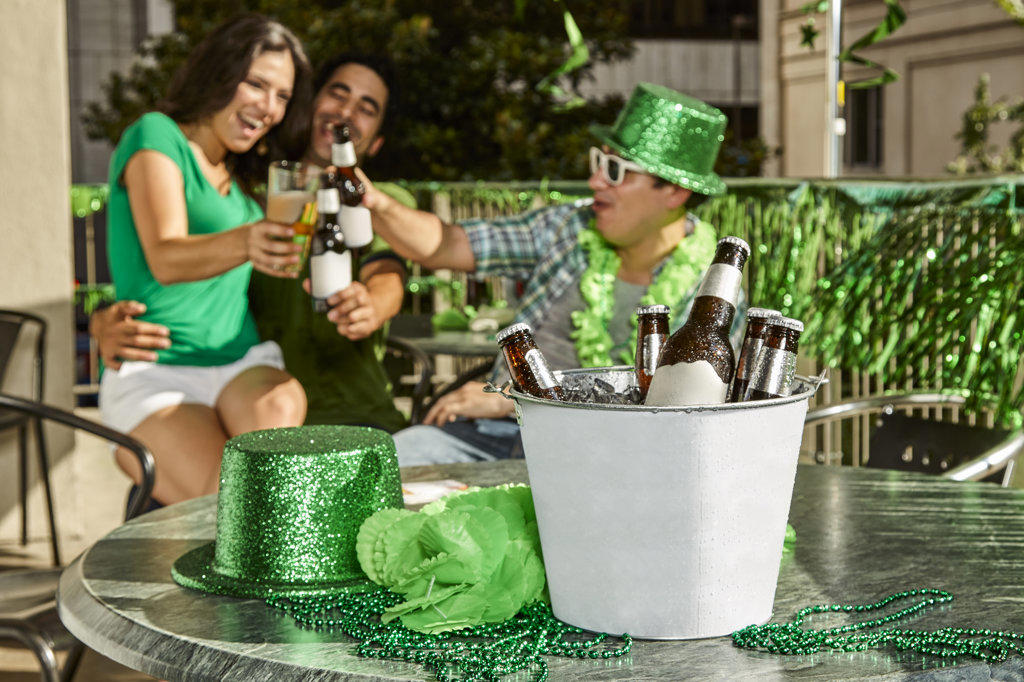Group of friends toasting in background with a bucket of beer in foreground. Focus on foreground. 