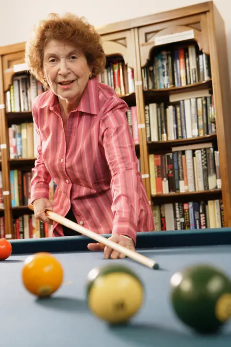 Elderly woman shooting pool