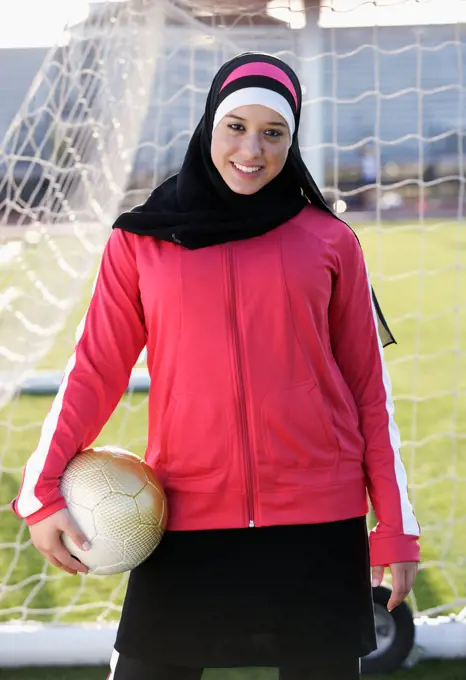 Muslim teenager holding soccer ball
