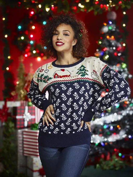 Portrait of an African America woman in ugly Christmas sweater looking at camera with hands on hips