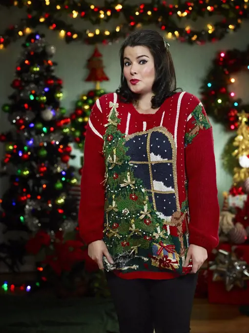 Portrait of woman in ugly Christmas sweater looking at camera surprised. 