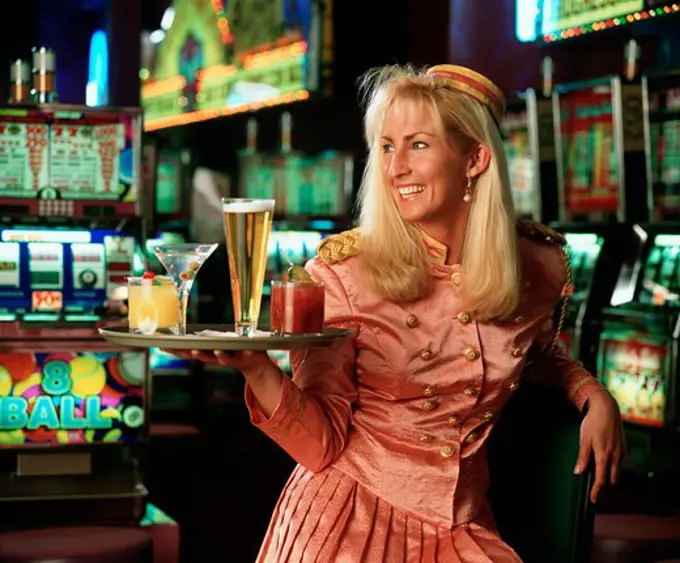 Casino waitress holding a tray of drinks and smiling