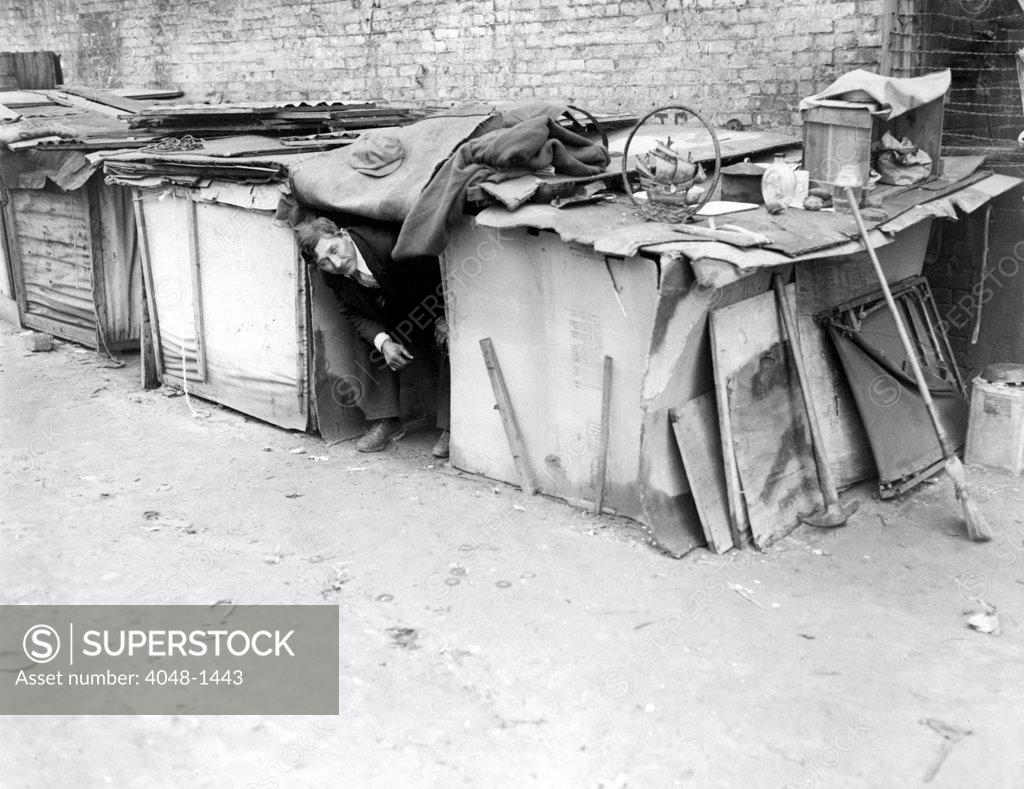 Stock Photo: 4048-1443 An unemployed man living in a shack constructed from packing cases and pieces of wood in New York City, off Broadway on West Houston Street.  February 8, 1933.