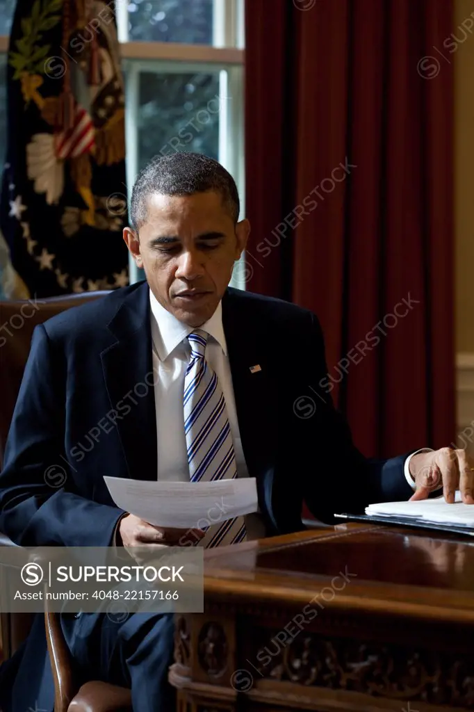 President Barack Obama reads a document in the Oval Office, Feb. 21, 2012. (BSLOC_2015_3_3)