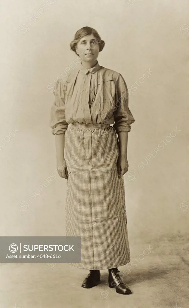 Suffragist Abby Scott Baker, models a prison dress. She was imprisoned for picketing in Washington, D.C. and wore her prison uniform as one of the speakers on the militant National Women's Party 'Prison Special' tour in Feb-Mar 1919.