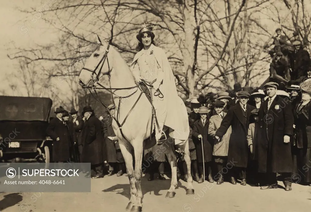 Inez Milholland, wearing white robes and a crown riding a white horse as the 'Herald' in the Women's Suffrage parade of March 3, 1913, the day prior to Woodrow Wilson's inauguration. It was the last major suffrage demonstration to use such theatrical costumes.