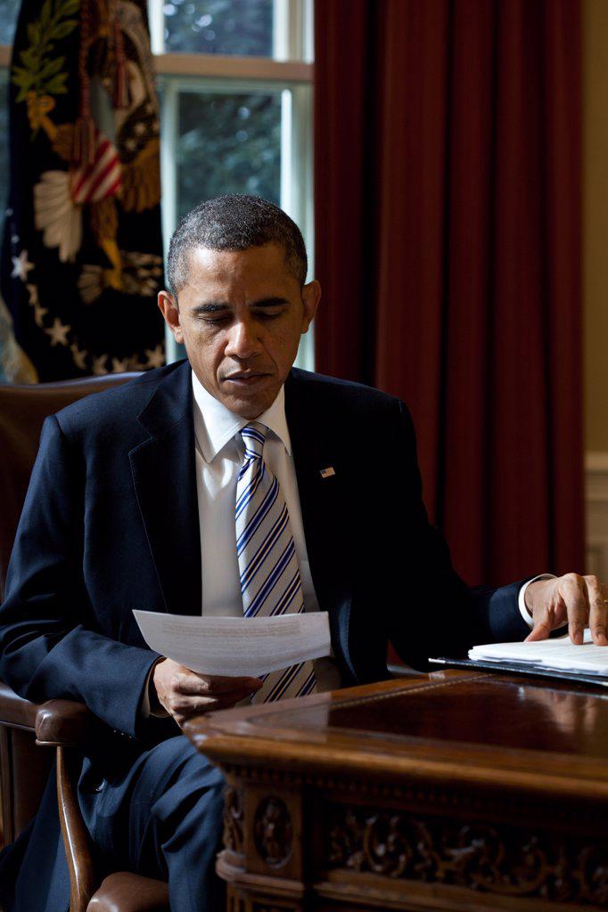 President Barack Obama reads a document in the Oval Office, Feb. 21, 2012. (BSLOC_2015_3_3)