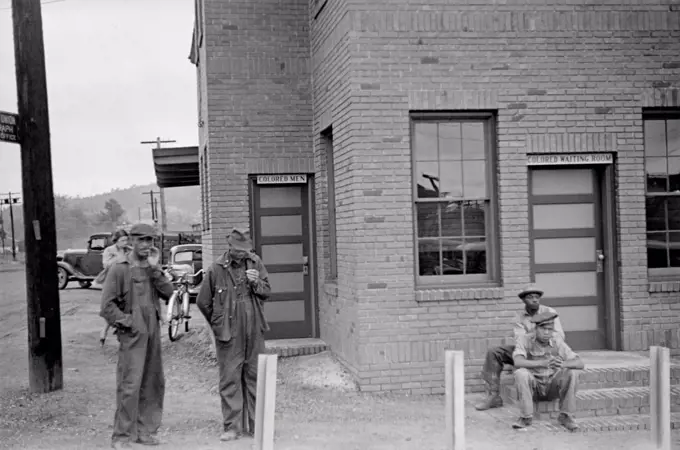 Colored Waiting Room sign. Four African American men stand outside of the Manchester, Georgia, railroad station. May 1938.