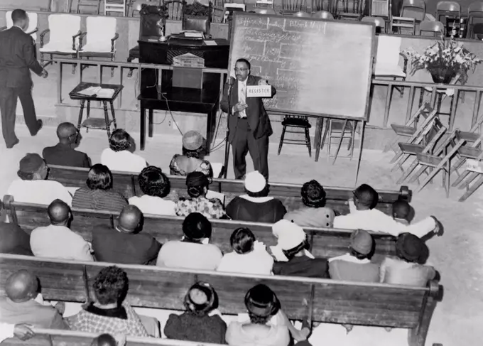 Voter registration drive. In a southern church basement, an African American leads a training session for a voter registration drive. Ca. 1950s.