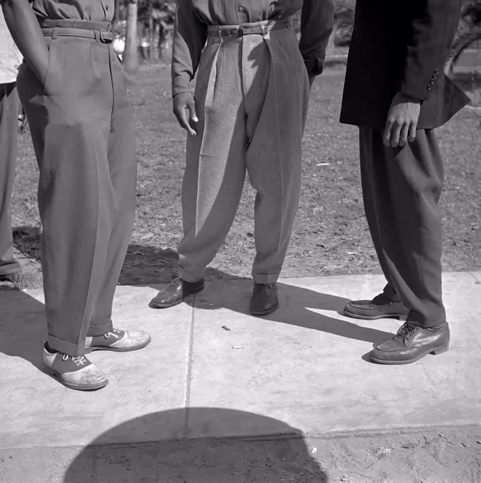 The 'Zoot Suit' styled trousers, called tramas, of three African American college students at Bethune-Cookman College.  The high-waisted, wide-legged, tight-cuffed pegged trousers fashion trend thrived in the Latino, and African American youth subcultures during the early 1940's era. January 1943 photo by Gordon Parks.