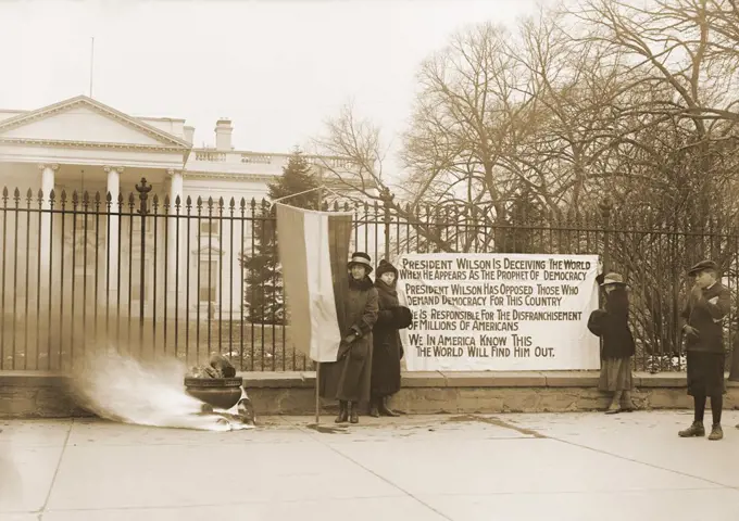 National Women's Party demonstration with a bonfire in front of the White House in 1918. The banner questions Wilson's commitment to democracy for his failure to support women's suffrage.