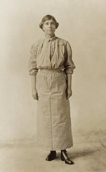 Suffragist Abby Scott Baker, models a prison dress. She was imprisoned for picketing in Washington, D.C. and wore her prison uniform as one of the speakers on the militant National Women's Party 'Prison Special' tour in Feb-Mar 1919.