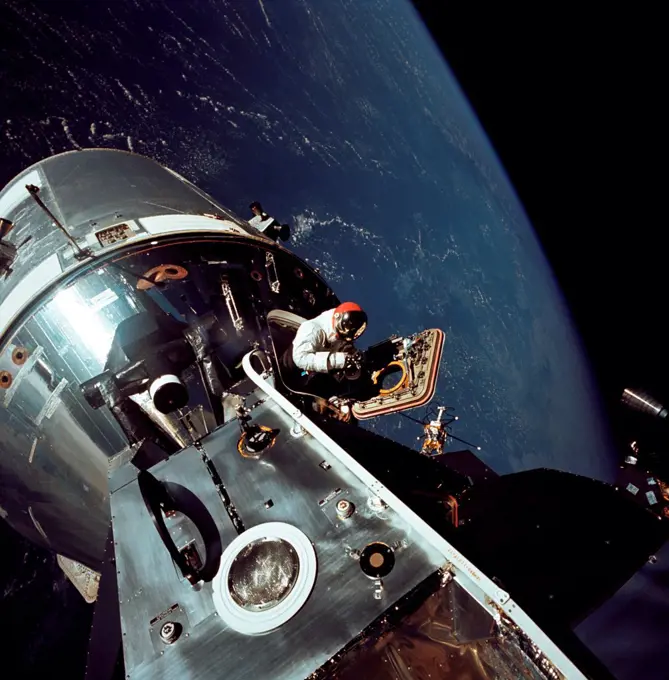Apollo 9 astronaut Dave Scott stands in the open hatch of the Command Module, docked to the Lunar Module in Earth orbit. Apollo 9 tested the orbital rendezvous and docking procedures that made the lunar landings possible. March 6, 1969.