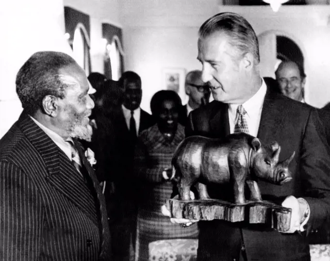 Vice President Spiro Agnew meeting with Kenya's Revolutionary President Jomo Kenyatta. Agnew holds a wooden carving of a rhinoceros presented to him by Kenyatta. July 12, 1971.