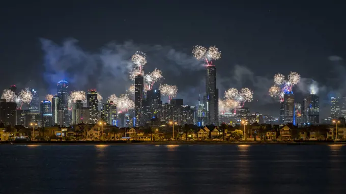 Fireworks over Melbourne city skyline for New Year celebrations. View from Port Philip Bay, St Kilda, Victoria, Australia. January 2018.