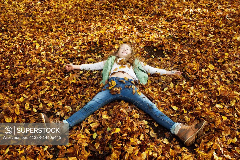 Girl lying in Autumn leaves