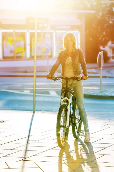 Young woman cycling in city
