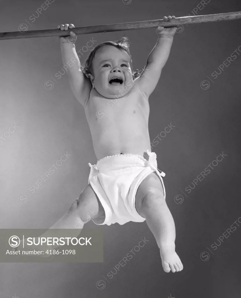 1960S Baby Suspended From Broom Handle With Frightened Expression On Verge  Of Tears - SuperStock