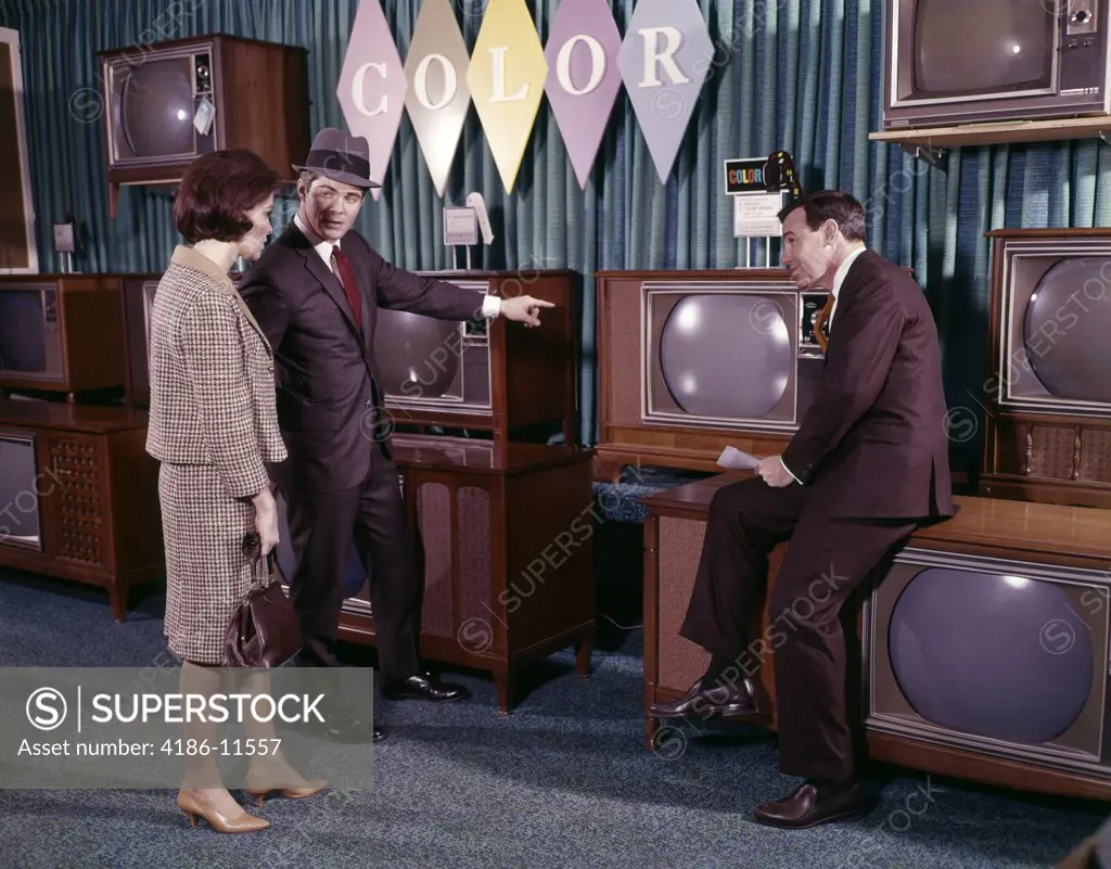1960S Couple Man Woman Talking To Salesman In Color Television Set Sales Department