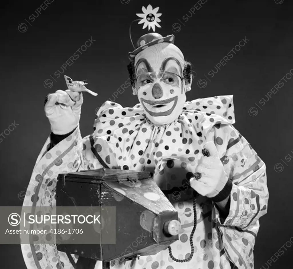 1960S Clown In Polka-Dotted Outfit Taking Picture With Old-Time Camera Holding Birdie In Opposite Hand