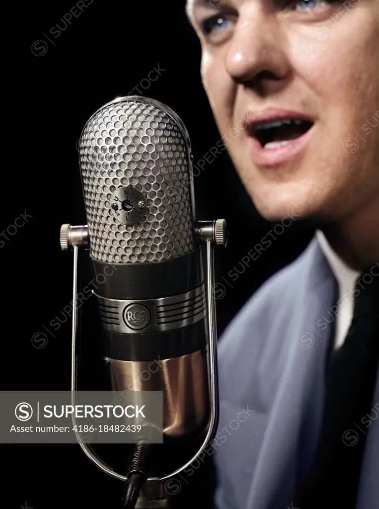 1950s CLOSE-UP OF MAN ANNOUNCER TALKING INTO MICROPHONE NEWSCASTER INDOOR SYMBOLIC FREEDOM OF SPEECH