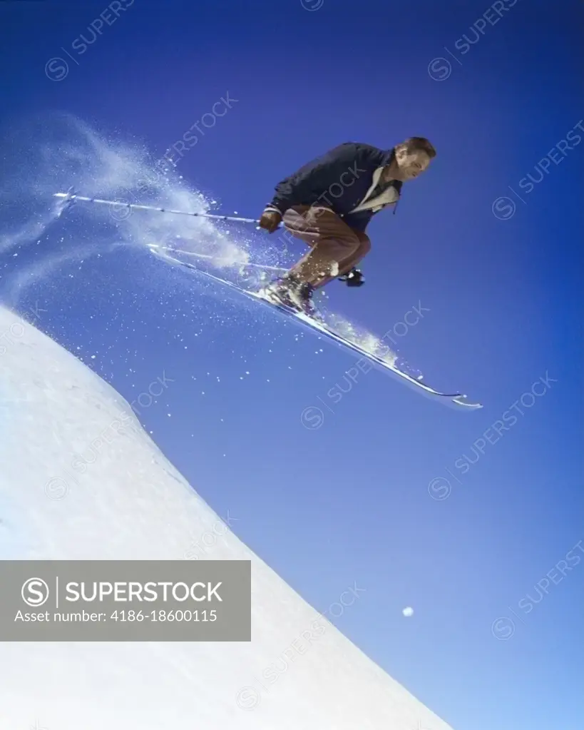 1950s MAN SKIING DOWNHILL OFF SLOPE JUMPING INTO AIR SKI SKIS SPORTS WINTER SNOW