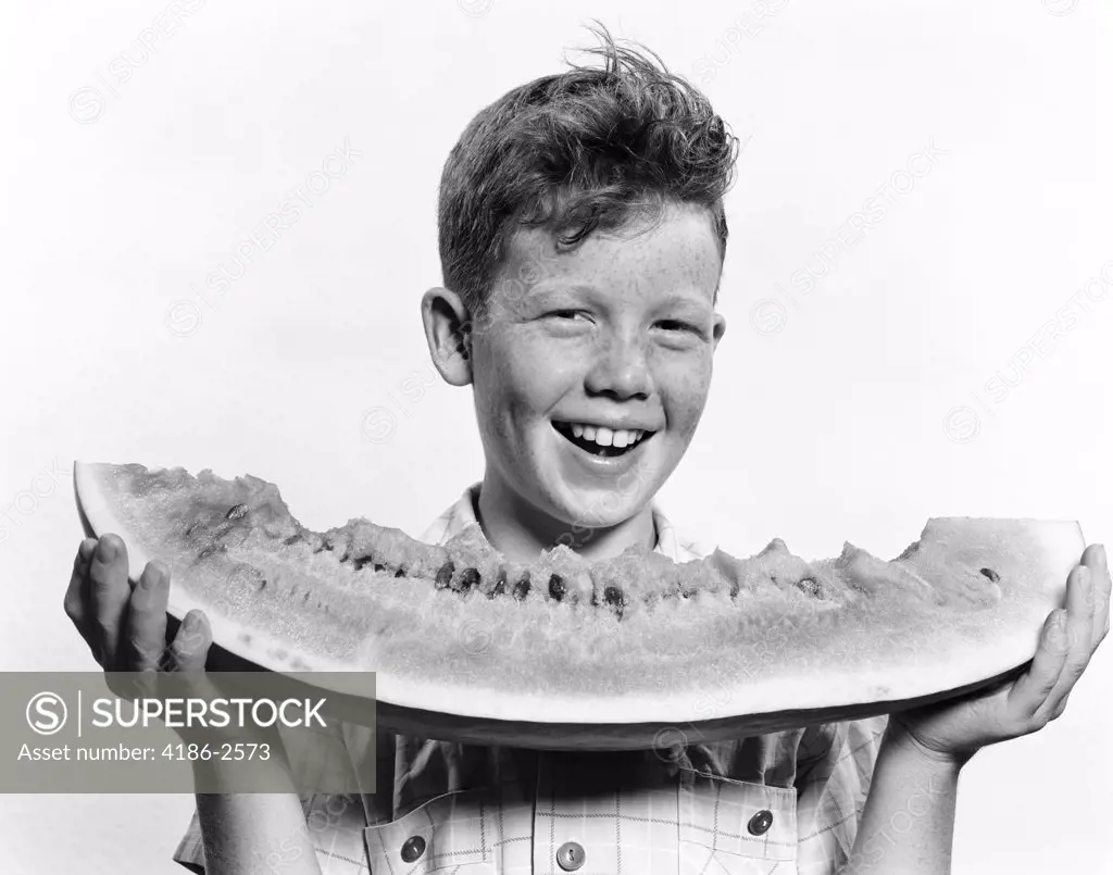 1940S 1950S Smiling Boy Holding Eating Large Slice Of Watermelon