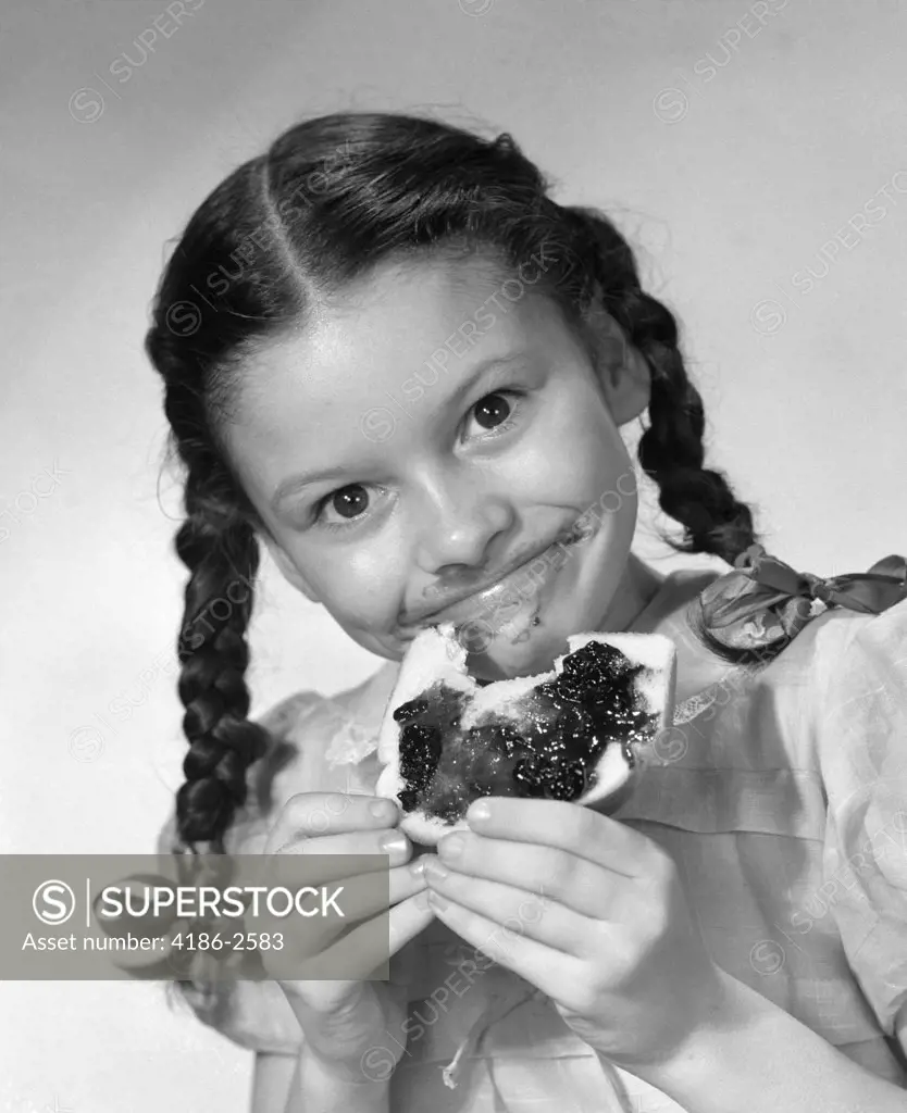 1950S Girl With Pigtails Eating Bread With Jelly Smeared On Her Face
