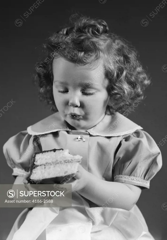 1940S Little Girl Eating Piece Of Cake With Chocolate Icing