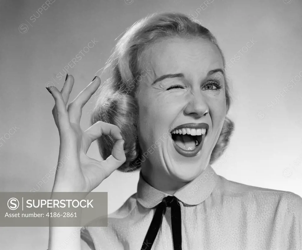 1950S Blond Woman Winking Eye And Making Ok Sign With Thumb And Finger