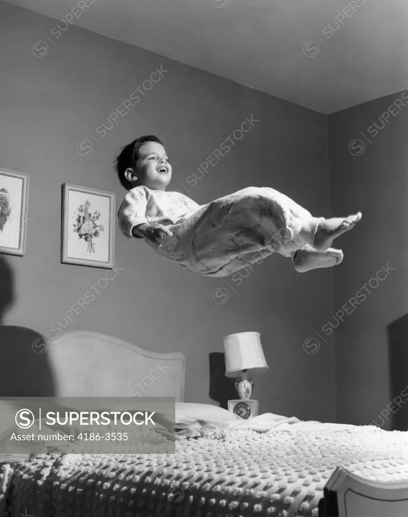 1950S Boy In Pajamas Elevated Above Bed