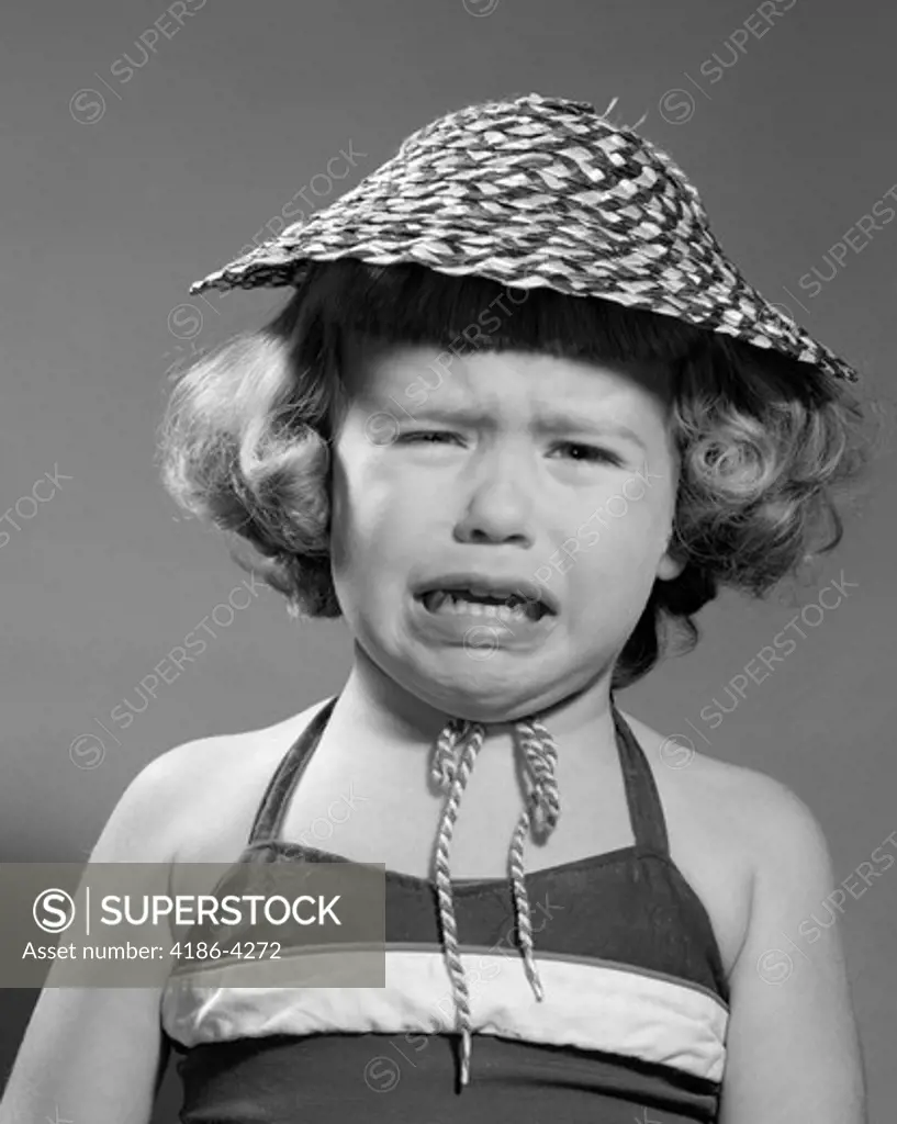 1960S Portrait Of Girl Wearing Straw Hat And Crying