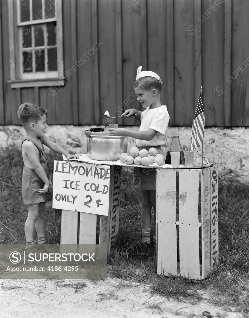 1930S 1940S Boy With Lemonade Stand Selling To Little Boy In Short Pants