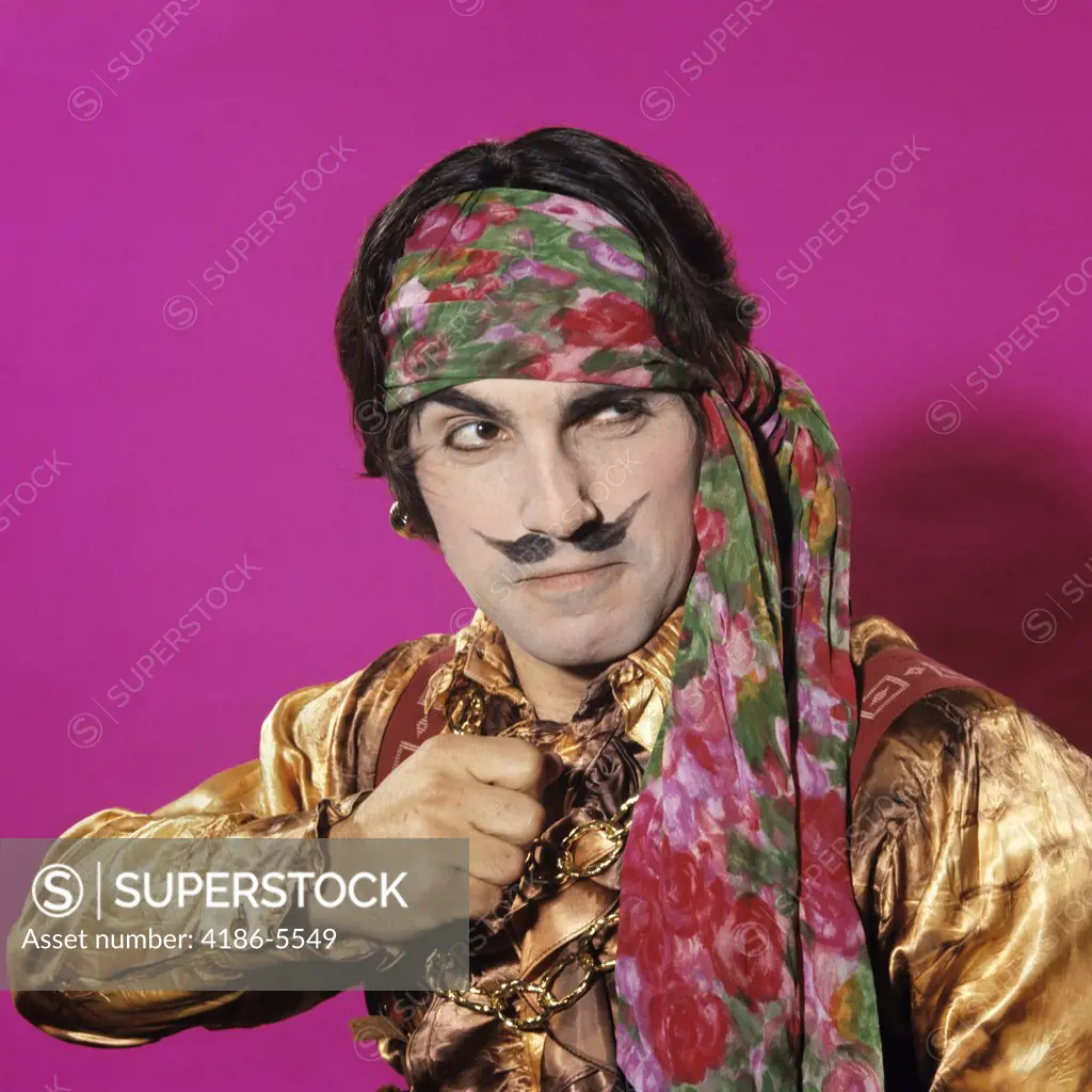 Character Man Funny Expression Gesture Dressed In Pirate Costume Fake Moustache Pink Background Gold Silk Shirt Headband
