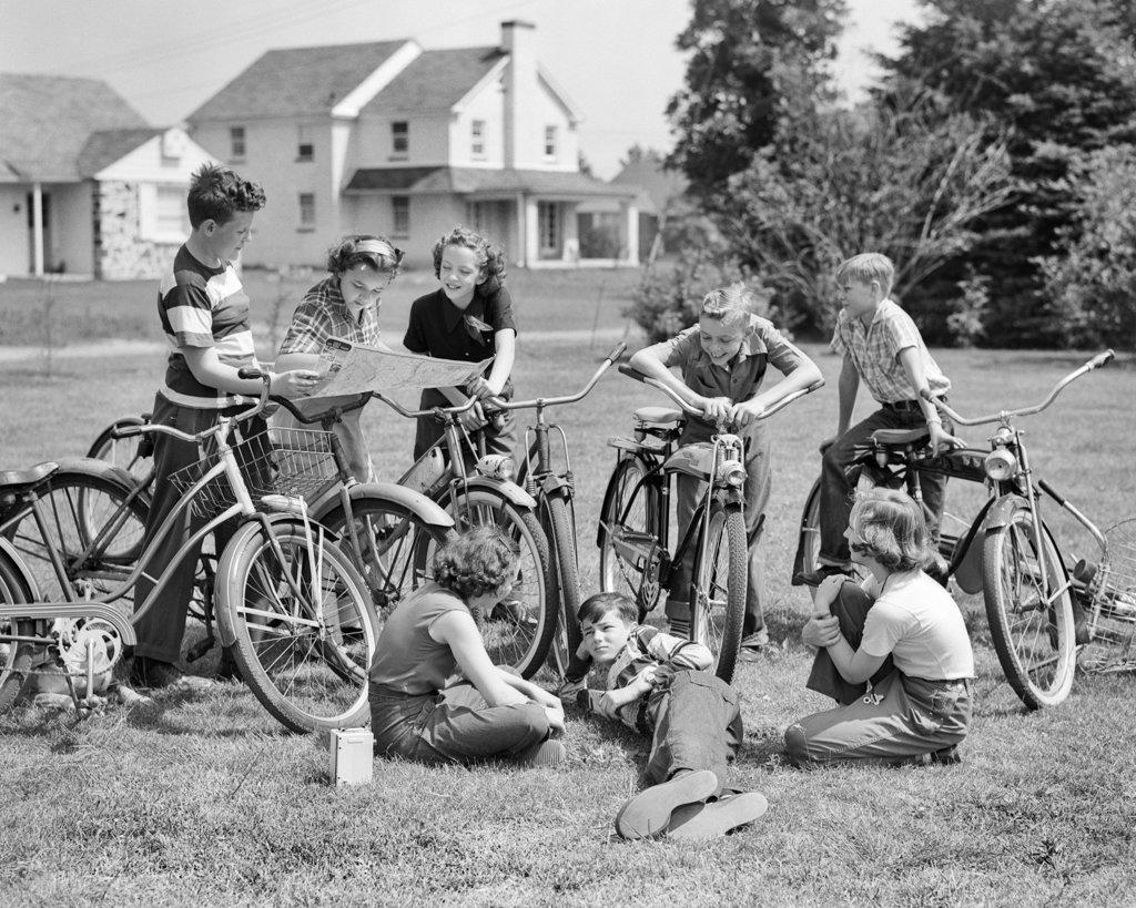 1950s 8 KIDS BOYS AND GIRLS WITH BIKES LOOKING AT A MAP PLANNING A SUMMER DAY ACTIVITY