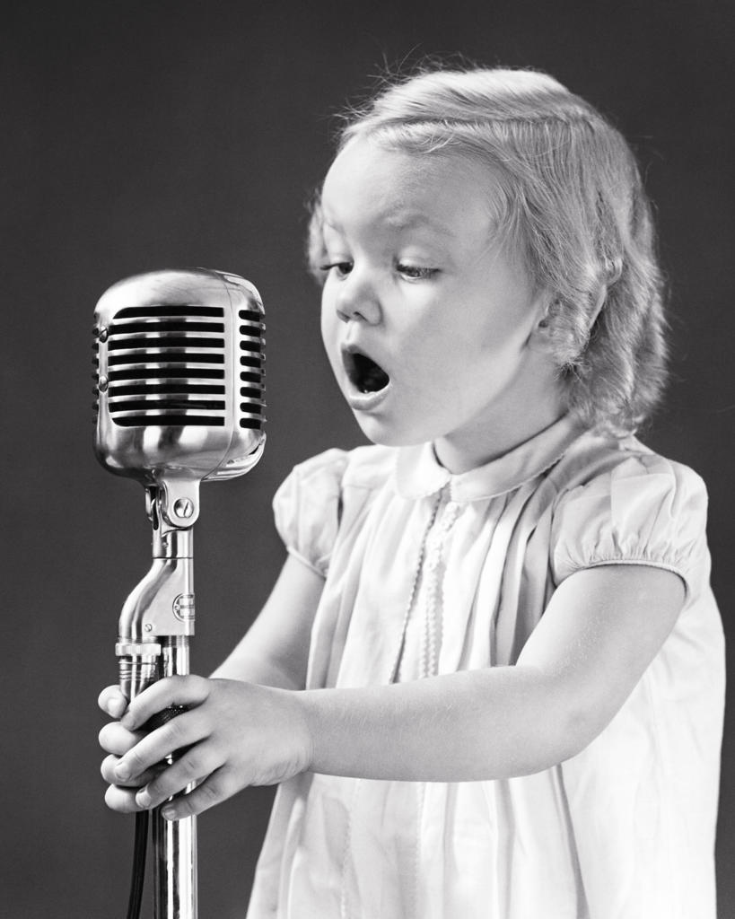 1930s 1940s EAGER YOUNG BLOND GIRL HOLDING SINGING INTO MICROPHONE