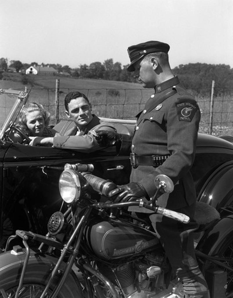 1930S Couple In Convertible Coupe Stopped By Motorcycle Cop Checking License Of Driver