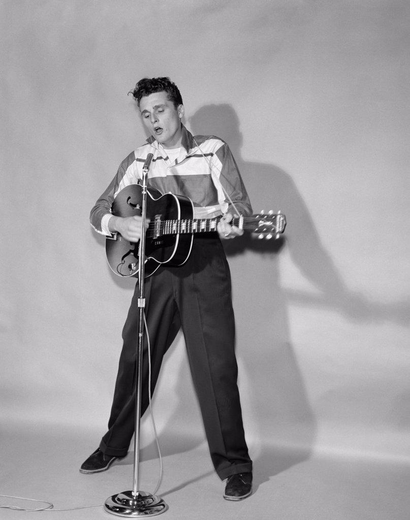 1950S Rockabilly Singer In Front Of Microphone Strumming Hollow-Body Guitar